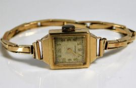 A 9ct gold ladies watch with yellow metal strap th