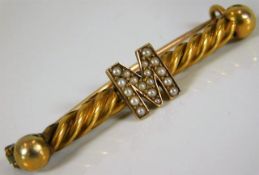 An antique bar brooch with yellow metal barley twi
