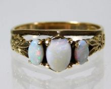 A 9ct gold ring set with three opals, one with chi