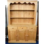 A farmhouse style pine dresser with three drawers