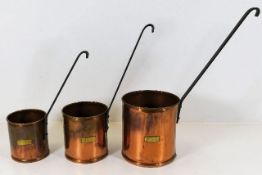 Three graduated antique copper grain measures