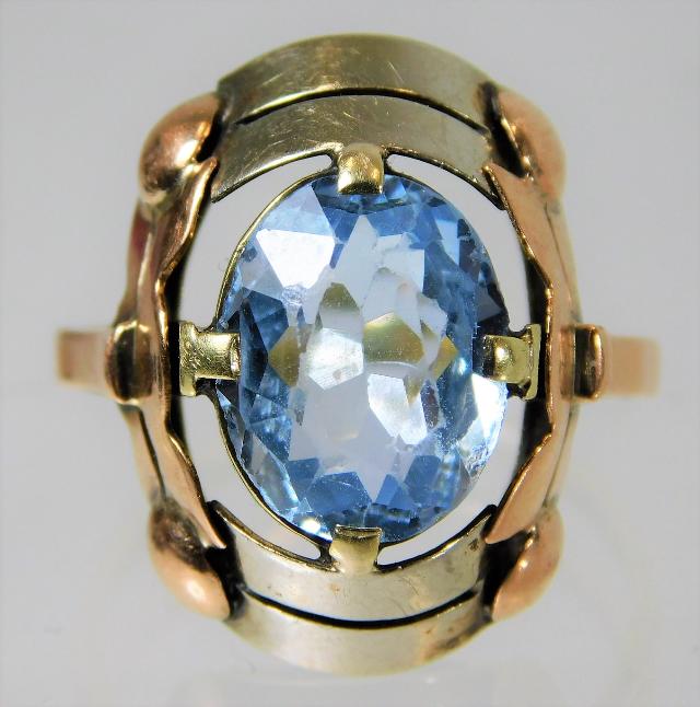 A three colour metal ring set with aquamarine ston