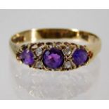 A 9ct gold ring set with amethyst (chip to side stone) & white stones 2.1g size T/U