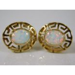 A pair of 14ct gold earrings set with opal style s