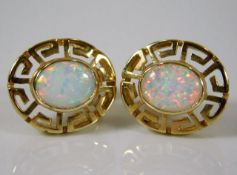 A pair of 14ct gold earrings set with opal style s