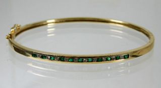 A 10ct gold diamond & emerald bangle 8.3g