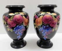 A pair of large decorative vases with fruit design