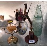 A brass wax jack, a brass mounted eyeglass, an antique glass lemonade bottle & a quantity of pens &