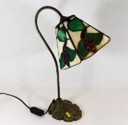 A decorative Tiffany style desk lamp with red berr