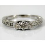A 9ct white gold ring set with 0.25ct diamond with additional pave set diamonds on shoulders & shank