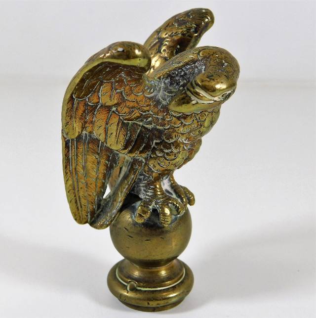 A brass eagle perched on sphere car mascot 3.5in t