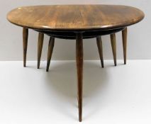 A nest of three retro Ercol elm pebble tables, lar