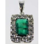 An 18ct white gold emerald pendant framed by 1.2ct