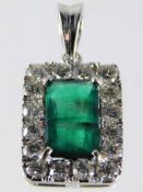 An 18ct white gold emerald pendant framed by 1.2ct