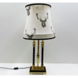 A decorative table lamp with stag decorated shade