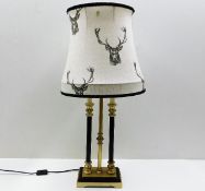 A decorative table lamp with stag decorated shade