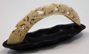 An early 20thC. small carved ivory tusk depicting