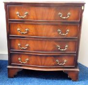 A small serpentine fronted chest of drawers with b