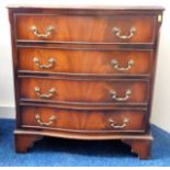 A small serpentine fronted chest of drawers with b