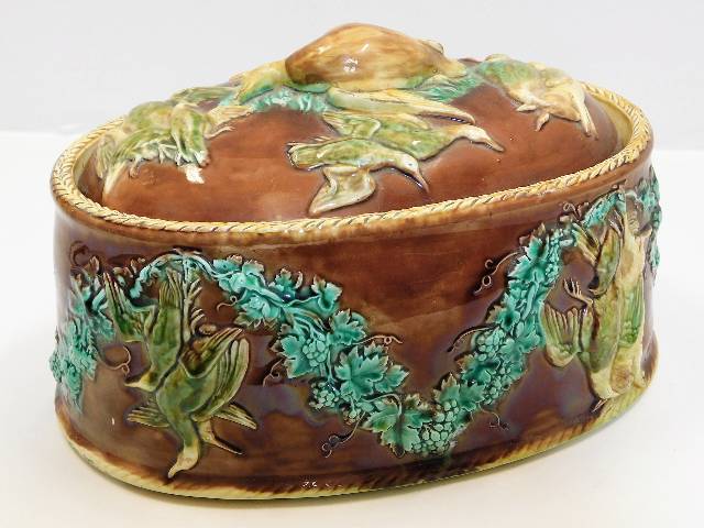 A 19thC. majolica game pot & cover, some faults to