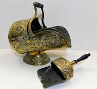 A decorative Victorian brass coal scuttle with mat