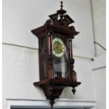 A varnished mahogany wall clock