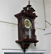 A varnished mahogany wall clock