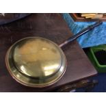 A brass bed warming pan