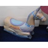 A low level carved wooden rocking horse