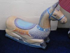 A low level carved wooden rocking horse