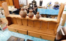 A rustic pine wall shelf with drawers