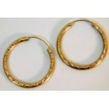 A pair of 9ct gold hoop earrings with chased decor