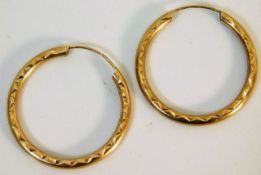 A pair of 9ct gold hoop earrings with chased decor