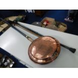 A copper bed pan with chased decor twinned with tw