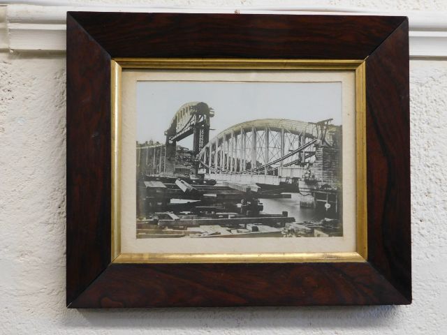 An oak framed photograph of the building of the Ro