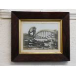 An oak framed photograph of the building of the Ro