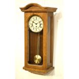 Modern oak-cased Vienna-style wall clock by Hermle with three-train chiming movement and gridiron