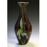 Large coloured glass vase of bulbous form with floral decoration of orchids or irises, 40.5cm high