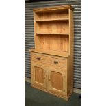 Stripped pine high dresser of narrow proportions with moulded cornice over two shelves and pot