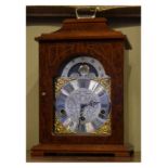 Reproduction mahogany finish cased mantel clock by Franz Hermle, having a brass and silvered dial