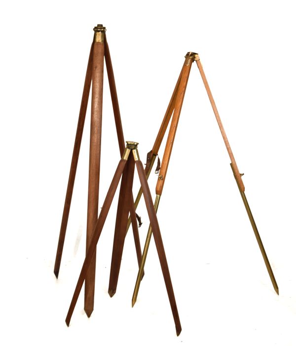 Three early to mid 20th Century surveyor's brass-mounted wooden stands for a theodolite, level or