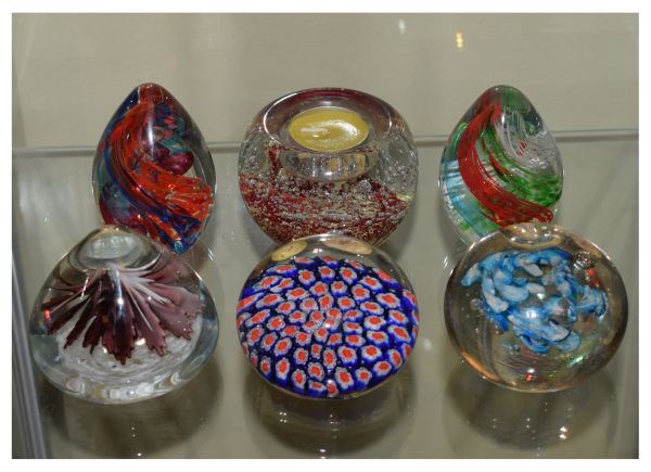 Six assorted glass paperweights to include; a millefiori example and another with candle recess (