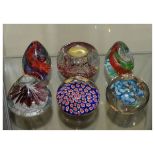 Six assorted glass paperweights to include; a millefiori example and another with candle recess (