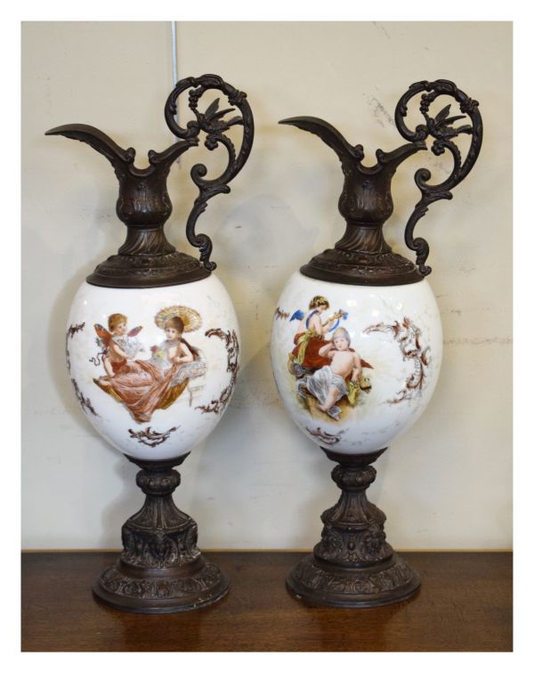 Pair of late 19th Century printed and painted white glass and metal mounted ewers, each depicting