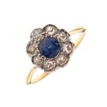Dress ring set central sapphire coloured stone within a diamond surround, the shank stamped 18ct,