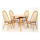 Modern Design - Ercol light elm and beech circular topped dining table standing on tapered