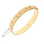 9ct gold snap bangle having engraved starburst decoration to one half, Birmingham 1991 with guard