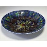 Poole Studio range shallow bowl having multi coloured 'splatter' decoration on a blue/green