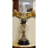 Victorian oil lamp having a clear cut glass reservoir and standing on a brass flared pillar with a