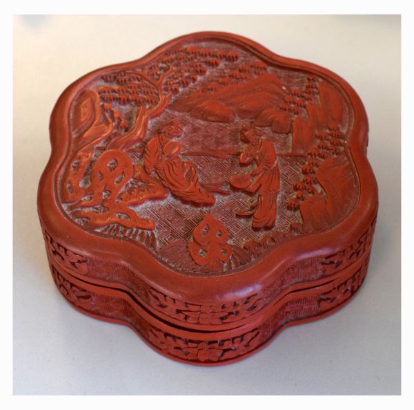 Chinese cinnabar lacquer floret shaped box and cover decorated with figures in a landscape